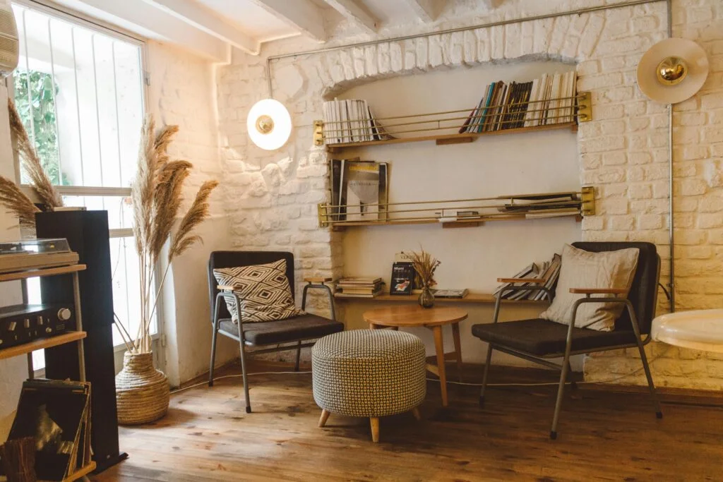 Avoid These Home Organization Mistakes! 1 Inviting modern rustic living room featuring armchairs, an ottoman, and a stylish bookshelf.